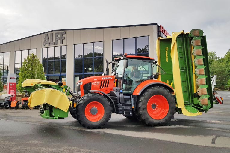 Kubota Traktor vor der Ausstellungshalle der Firma ALFF mit Krone Front- und Heckmäher